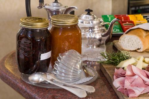 a counter with two jars of honey and a plate of food at Hotel Cacciani in Frascati