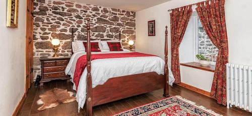 a bedroom with a bed and a stone wall at Mill Of Nethermill Holidays in Pennan