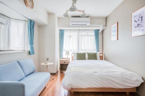 a bedroom with a bed and a couch at Park Residence Omori in Tokyo