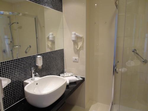 
a bathroom with a sink, mirror, and bathtub at Hotel Michelino Bologna Fiera in Bologna
