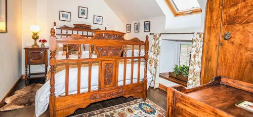 a bedroom with a large wooden bed in a room at Mill Of Nethermill Holidays in Pennan