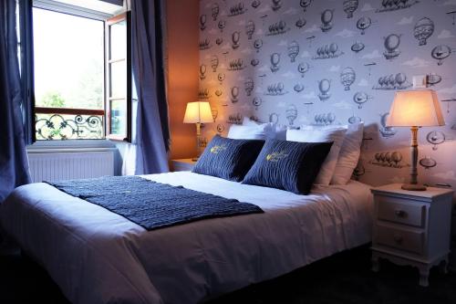 a bedroom with a bed with a wall covered in plates at Hôtel Au Coq Dort Spa in Châtillon-sur-Chalaronne