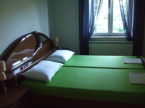 a green bed in a room with a window at Villa Anita in Kraljevica