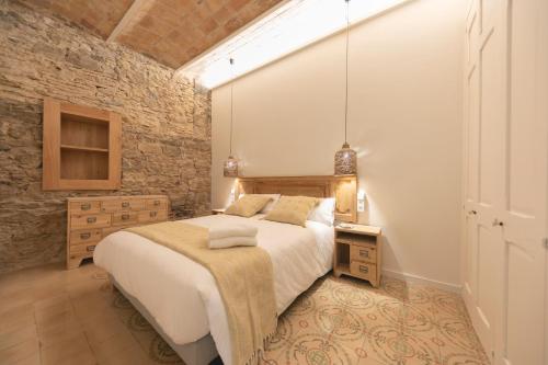 a bedroom with a large bed and a brick wall at Bravissimo Mercaders, beautiful 3 bedroom apartment in Girona