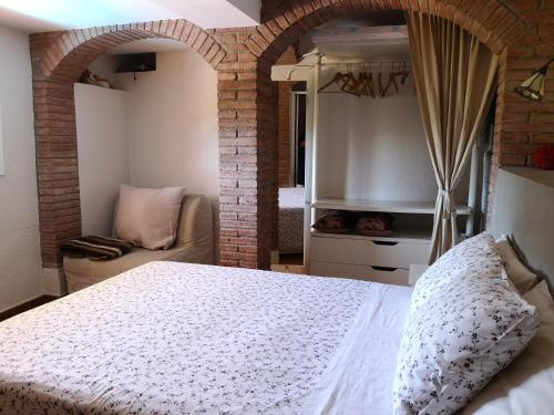 sypialnia z białym łóżkiem i kanapą w obiekcie Casita con piscina y barbacoa privada w Blanes