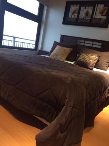 a large bed in a bedroom with two windows at Hotel HF in Farellones