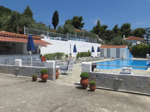 a villa with a swimming pool and potted plants at Poseidon in Stafylos