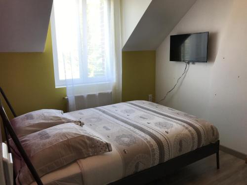 sypialnia z łóżkiem i telewizorem na ścianie w obiekcie Résidence Henri Dunant w mieście Valenciennes