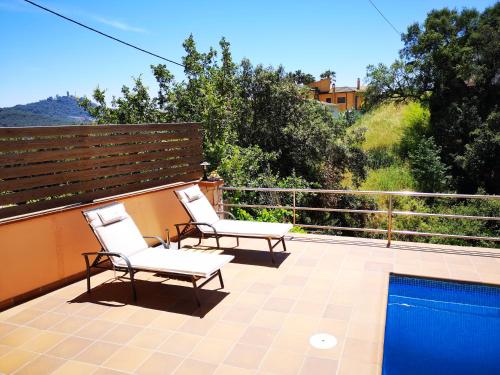 two chairs sitting on a balcony with a pool at Casita con piscina y barbacoa privada in Blanes