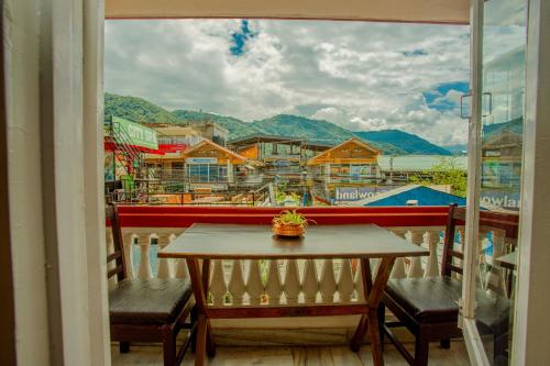 a table and chairs on a balcony with a view at Hotel Snowland in Pokhara