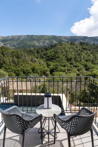 two chairs and a table on a balcony with a view at Hôtel Sainte Victoire in Vauvenargues