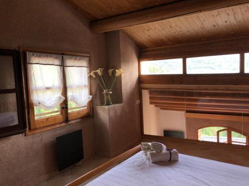 a bedroom with a bed and two windows and a vase of flowers at CASA RUGALL in Monrós
