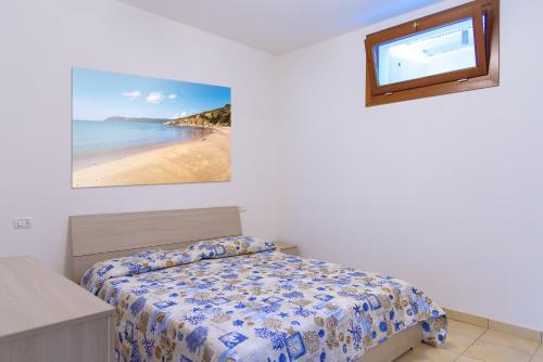 sypialnia z łóżkiem i widokiem na plażę w obiekcie Appartamenti Godiamoci Capoliveri w mieście Capoliveri
