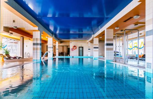 a swimming pool in a building with blue tiles at Hotel Victoria in Wejherowo