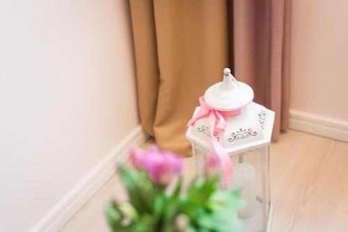 a glass jar with a pink bow next to flowers at Hotel Maritimo in Makarska