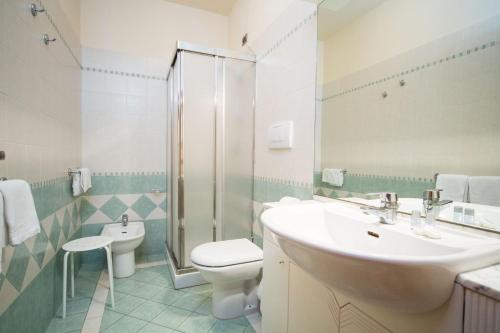 y baño con lavabo, aseo y ducha. en Albergo Roma, en Casciana Terme