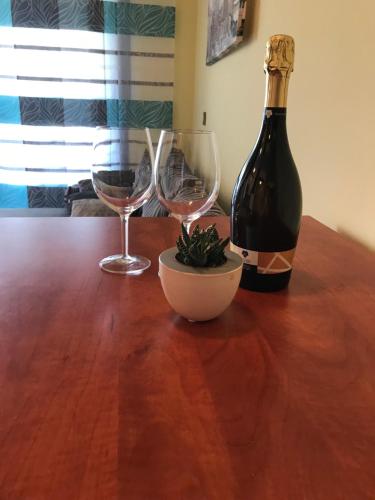 a bottle of wine and two glasses on a wooden table at Studio Apartman Lorenzo in Umag