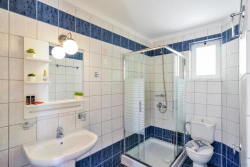 a bathroom with a toilet and a sink and a shower at Poseidon Apartments in Kato Daratso