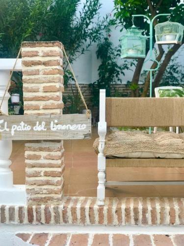 a sign that says la paza do iguana next to a bench at El Patio del Limonero in Écija