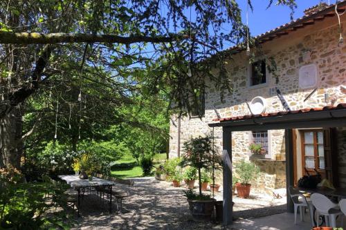 a garden with a table and a building at Ala di Maniero in Agriturismo Valdrago in Toscana, nel Verde Mugello sulle Colline di Firenze Autodromo Mugello Circuit in Borgo San Lorenzo