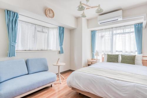 a bedroom with a bed and a couch at Park Residence Omori in Tokyo