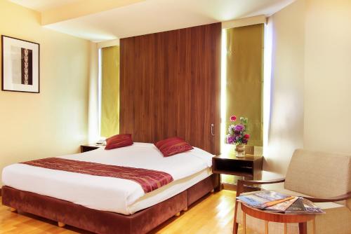 1 dormitorio con 1 cama, 1 mesa y 1 silla en Bally Suite Silom, en Bangkok