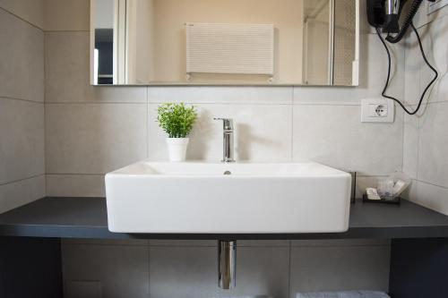 a white bathroom sink with a potted plant on it at Casa Beccherie in Lazise