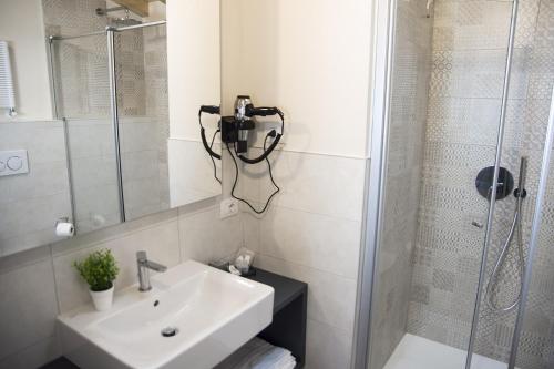 a bathroom with a sink and a shower with a camera on the wall at Casa Beccherie in Lazise