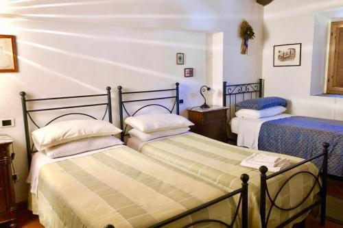 a bedroom with two beds in a room at Ala di Maniero in Agriturismo Valdrago in Toscana, nel Verde Mugello sulle Colline di Firenze Autodromo Mugello Circuit in Borgo San Lorenzo