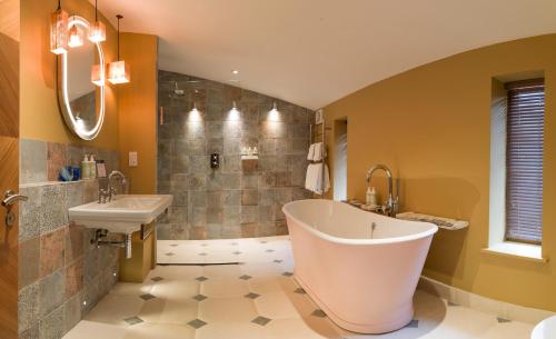 a bathroom with a large tub and a sink at Homewood Hotel & Spa - Small Luxury Hotels of the World in Bath