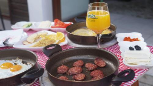 a table with two pans of food and a glass of orange juice at Saray Hotel in Prizren
