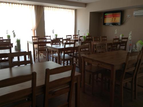 a dining room with wooden tables and chairs at Olimpiska Centra Ventspils Hotel in Ventspils