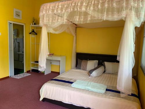 a bedroom with a bed with a canopy at Happy Paradise in Kampung Janda Baik