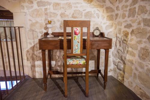 a wooden desk with a chair and a clock at SI-Moutique Le Case degli Avi barocche, con terrazza panoramica in Modica