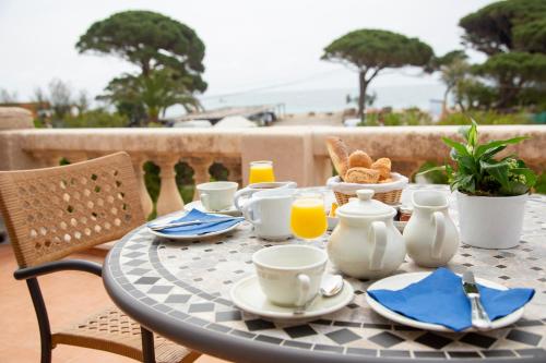 einen Tisch mit einem Frühstück mit Kaffee und Orangensaft in der Unterkunft Hôtel Saint Andre in Saint-Tropez