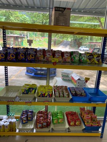 a store shelf filled with lots of food at Happy Paradise in Kampung Janda Baik