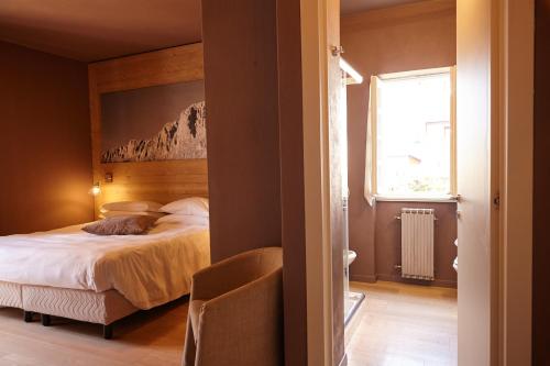 a bedroom with a bed and a window at Lo Chalet in Castione della Presolana