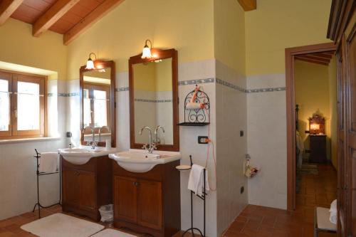 een badkamer met 2 wastafels en 2 spiegels bij RELAIS ANTICA CORTE AL MOLINO - Adults Only in Negrar
