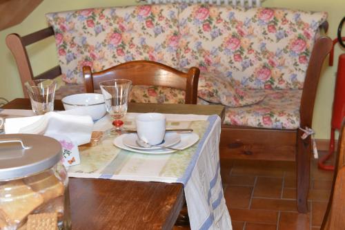 a dining room table with a table cloth on it with a couch at RELAIS ANTICA CORTE AL MOLINO - Adults Only in Negrar