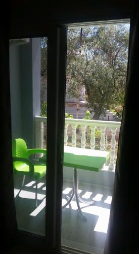 a green table and a green chair on a balcony at Vila DINI Ksamil in Ksamil