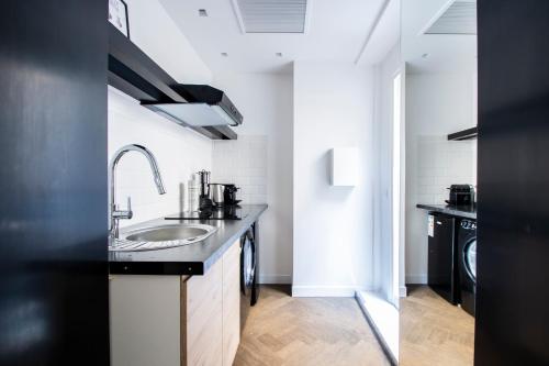 a black and white kitchen with a sink at Dreamyflat - Eiffel tower in Paris