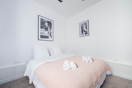 een witte slaapkamer met een bed met twee handdoeken erop bij Dreamyflat - Eiffel tower in Parijs