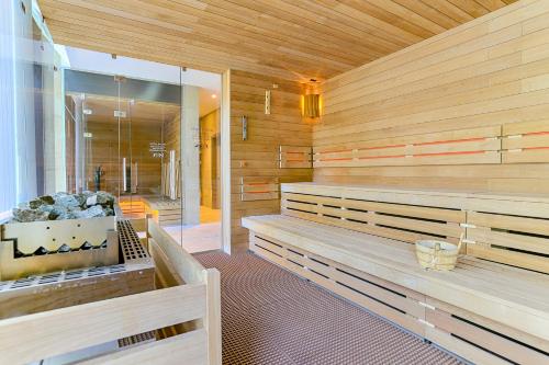 a sauna with wooden benches and a tub in it at Ensana Thermia Palace in Piešťany