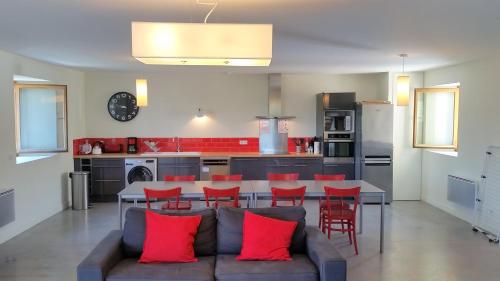 - un salon avec un canapé et une table avec des oreillers rouges dans l'établissement Gites Domaine de Ceyrac, à Conqueyrac