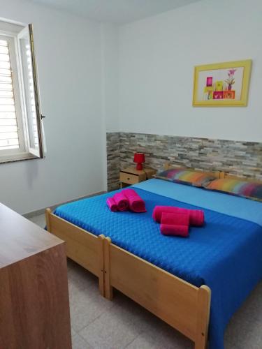 a bedroom with a bed with red pillows on it at Casa Verde in Cala Gonone