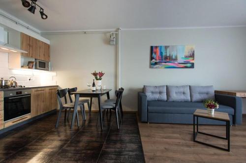 eine Küche und ein Wohnzimmer mit einem Tisch und einem Sofa in der Unterkunft VIP Apartment AVALON in Lwiw