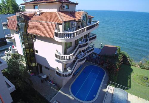 a building with a swimming pool in front of the ocean at Hotel Continental in Kiten