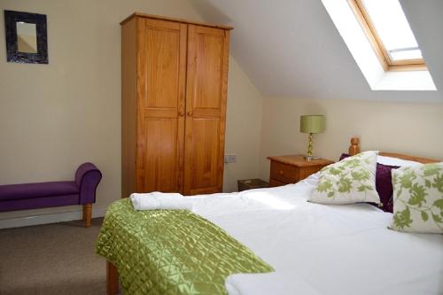 sypialnia z białym łóżkiem i drewnianą szafką w obiekcie Sand Dunes Penthouse Apartment w mieście Perranporth