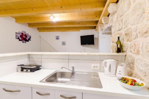 a kitchen with a sink and a bowl of food at Apartment Little Star II in Dubrovnik