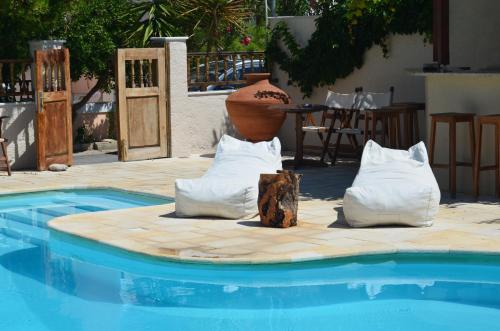 a pool with two pillows and a vase sitting next to at Sunrise Hotel in Samos